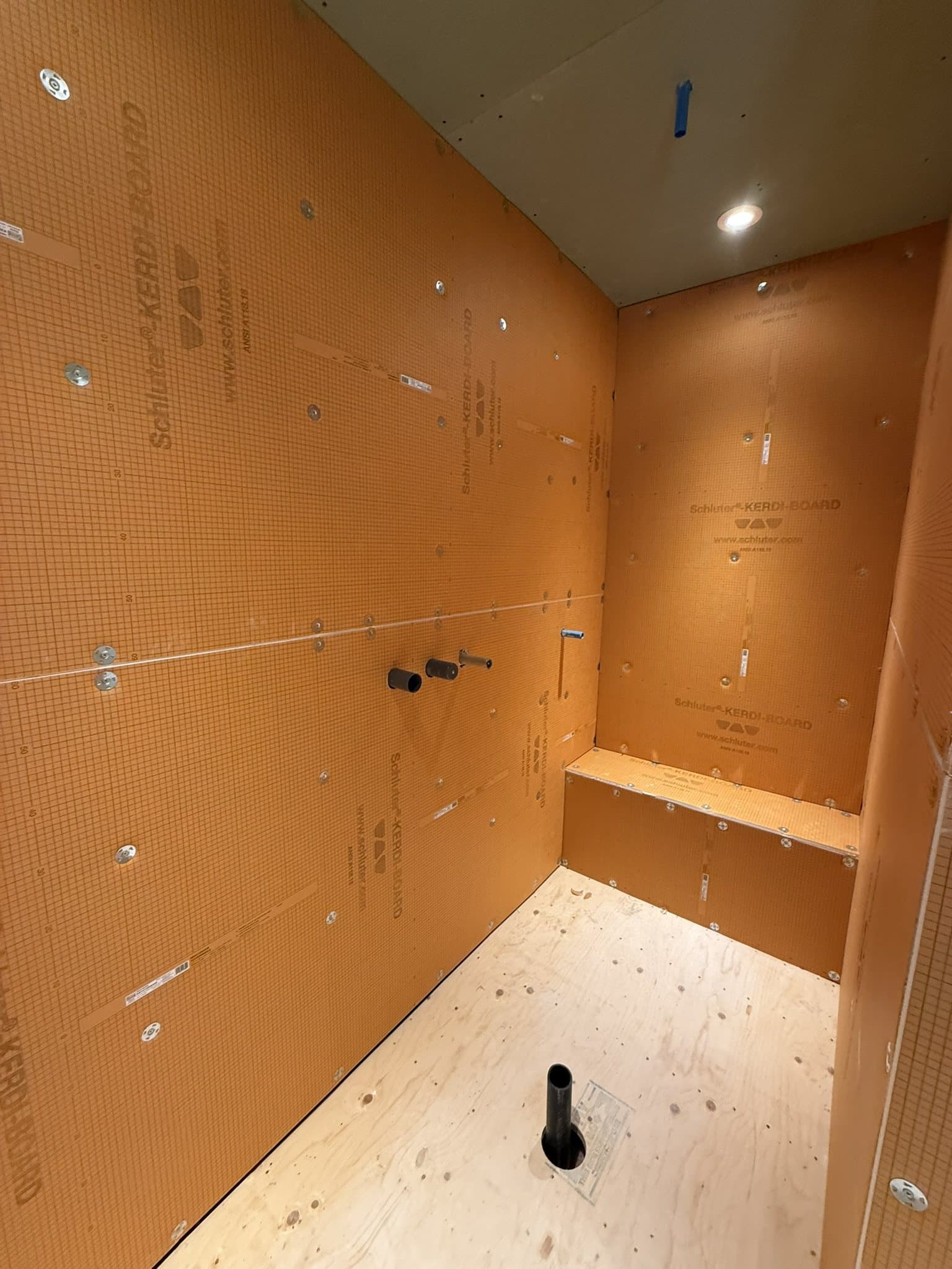Douche en construction : membrane d’étanchéité et banc maçonné