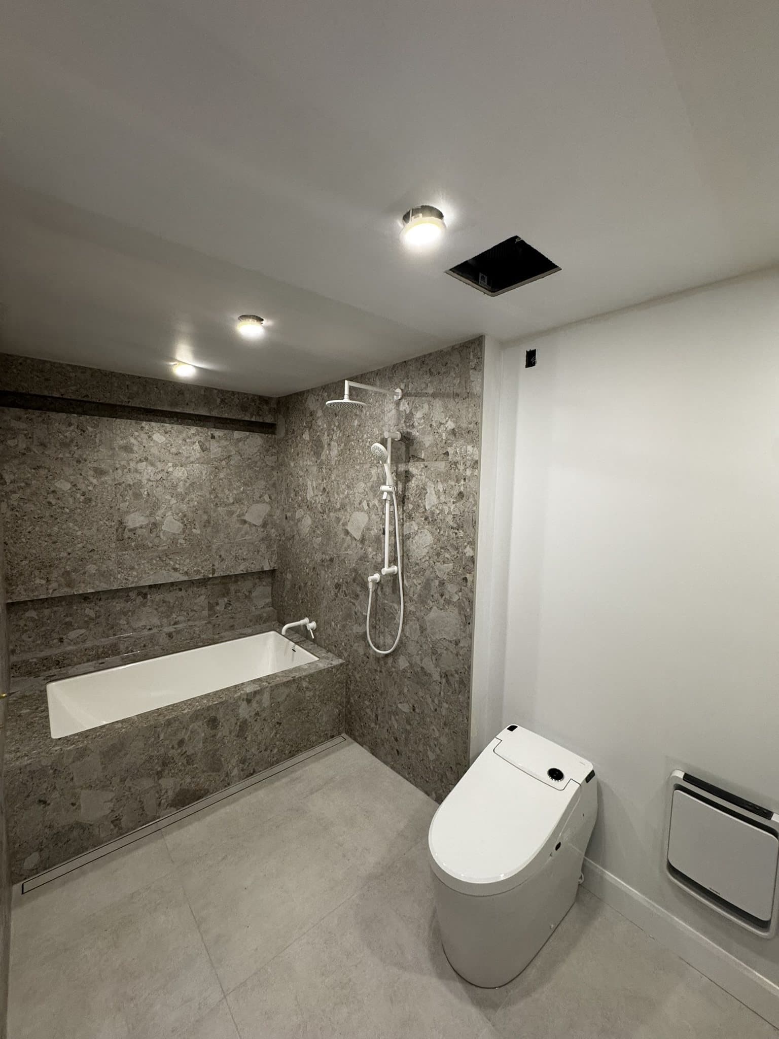 Salle de bain avec banc de douche intégré et céramique effet pierre