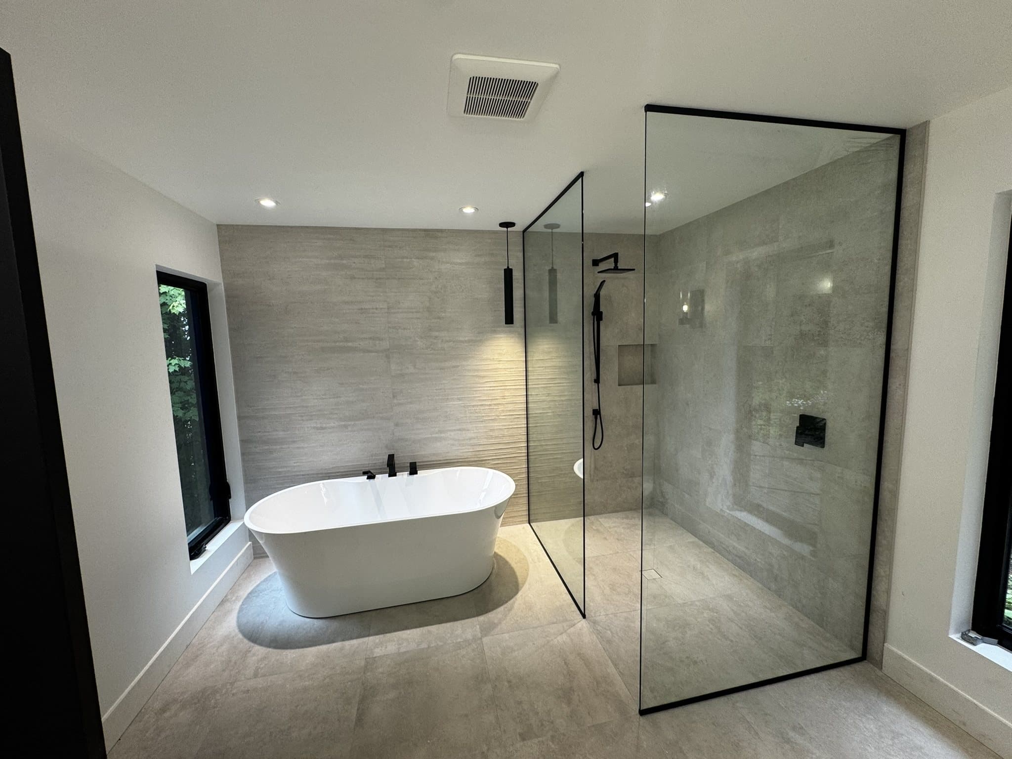 Salle de bain principale avec bain autoportant et douche à l’italienne fermée par une paroi vitrée